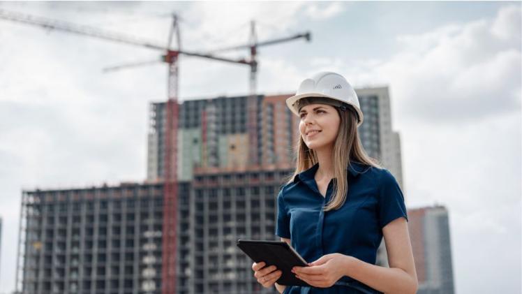 female student standing on a building roof wearing a hard hat